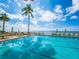 Relaxing pool with chairs and umbrellas, surrounded by palm trees and ocean views at 2295 Gulf Of Mexico Dr # 64S, Longboat Key, FL 34228