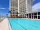 Luxury condo pool with palm trees, lounge chairs, and ocean view at beachfront property at 2295 Gulf Of Mexico Dr # 64S, Longboat Key, FL 34228
