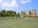 Well-maintained tennis court with landscaping and condo buildings in the background at 2295 Gulf Of Mexico Dr # 64S, Longboat Key, FL 34228