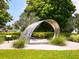 Landscaped yard featuring a unique, eye-catching metal sculpture with manicured bushes at 2295 Gulf Of Mexico Dr # 64S, Longboat Key, FL 34228