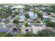 An aerial view of a residential neighborhood featuring mature trees, well-maintained lawns, and a serene lake at 2381 Appaloosa Cir, Sarasota, FL 34240