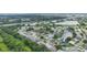 An aerial view of a community with a lake, lush trees, and many houses with solar panels on the roofs at 2381 Appaloosa Cir, Sarasota, FL 34240