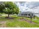 Spacious backyard featuring lush lawn, mature trees, and a screened-in lanai, ideal for outdoor relaxation at 2381 Appaloosa Cir, Sarasota, FL 34240