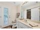 Bathroom with a single sink vanity, tiled shower, and outdoor access at 2381 Appaloosa Cir, Sarasota, FL 34240