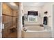 Well-lit bathroom featuring a soaking tub, step-in shower, and modern fixtures at 2381 Appaloosa Cir, Sarasota, FL 34240