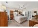 Bright bedroom with wood furniture, ceiling fan, sliding doors, and a relaxing rocking chair at 2381 Appaloosa Cir, Sarasota, FL 34240