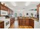 Bright kitchen featuring granite countertops, wood floors, and white appliances at 2381 Appaloosa Cir, Sarasota, FL 34240