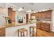 Bright kitchen featuring wood floors, breakfast bar, wood cabinetry, and granite countertops at 2381 Appaloosa Cir, Sarasota, FL 34240