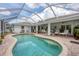 Backyard pool with covered seating area and brick paved deck at 2381 Appaloosa Cir, Sarasota, FL 34240