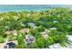 Beautiful aerial view of neighborhood homes surrounded by water and lush trees under a clear sky at 2504 Mulberry Ter, Sarasota, FL 34239