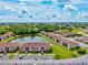 Aerial shot of condo community with multiple buildings, a pond with a fountain, and ample parking at 25100 Sandhill Blvd # 104 G, Punta Gorda, FL 33983