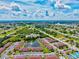 An aerial view of a residential community featuring condos around a central pond at 25100 Sandhill Blvd # 104 G, Punta Gorda, FL 33983