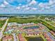 This aerial shot showcases the community layout with condos and a central pond feature at 25100 Sandhill Blvd # 104 G, Punta Gorda, FL 33983
