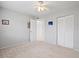 Bedroom featuring neutral carpet, ceiling fan, ample closet space, and open doorway at 25100 Sandhill Blvd # 104 G, Punta Gorda, FL 33983