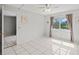 Bedroom with tile floors, ceiling fan, and a picturesque view of the pond at 25100 Sandhill Blvd # 104 G, Punta Gorda, FL 33983