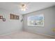 Cozy bedroom with carpet flooring, ceiling fan, and a sunlit window at 25100 Sandhill Blvd # 104 G, Punta Gorda, FL 33983