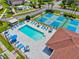 Overhead view of the community pool with lounge seating, tennis courts, and clubhouse at 25100 Sandhill Blvd # 104 G, Punta Gorda, FL 33983