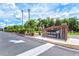 Community sign for Deep Creek Gardens with lush landscaping and clear skies at 25100 Sandhill Blvd # 104 G, Punta Gorda, FL 33983