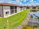 Exterior view of condo units with screened patios overlooking the grass and pond at 25100 Sandhill Blvd # 104 G, Punta Gorda, FL 33983