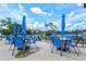 Outdoor seating area with tables, chairs and umbrellas near tennis courts at 25100 Sandhill Blvd # 104 G, Punta Gorda, FL 33983