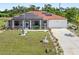 Charming single-story home featuring a red roof, solar panels, well-manicured lawn and a long driveway at 25324 Alicante Dr, Punta Gorda, FL 33955