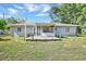 Rear exterior showing a wooden deck, screened-in porch, lawn and landscaping at 2622 11Th W Ave, Bradenton, FL 34205