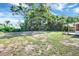 Large backyard showing a grassy area, a treeline and a wooden deck at 2622 11Th W Ave, Bradenton, FL 34205