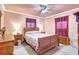 Warm bedroom with a wood sleigh bed, a ceiling fan, tile floors and decorative curtains, offering a cozy retreat at 2622 11Th W Ave, Bradenton, FL 34205