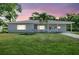 Charming single-story home with a spacious front yard and a welcoming covered porch under a colorful sunset at 2622 11Th W Ave, Bradenton, FL 34205