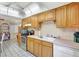 Kitchen featuring tile floor, white appliances, and wood cabinets at 2622 11Th W Ave, Bradenton, FL 34205