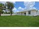 An ample backyard with healthy lawn, white fencing, and a covered lanai at 2794 Escambia Cir, North Port, FL 34288