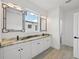 Bathroom featuring double vanities with stone countertop, undermount sinks and designer mirrors at 2794 Escambia Cir, North Port, FL 34288