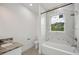 Bathroom featuring a tub, tile surround, window, and marble vanity top at 2794 Escambia Cir, North Port, FL 34288