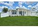 Modern home showcasing a well-maintained lawn, gray trim, and a white perimeter fence at 2794 Escambia Cir, North Port, FL 34288
