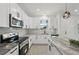 Modern kitchen with stainless steel appliances, white cabinetry, and island with stone countertop at 2794 Escambia Cir, North Port, FL 34288