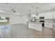 Open-concept living and kitchen area with island, white cabinetry, and tile floors at 2794 Escambia Cir, North Port, FL 34288