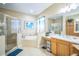 Bathroom featuring a double vanity, soaking tub, and glass shower enclosure at 3041 Stonegate Falls Dr, Land O Lakes, FL 34638