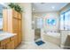 Bright bathroom with a soaking tub, glass shower, and oak cabinets at 3041 Stonegate Falls Dr, Land O Lakes, FL 34638