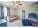 Comfortable bedroom with a ceiling fan, carpet flooring, and a cozy seating area at 3041 Stonegate Falls Dr, Land O Lakes, FL 34638