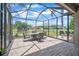 Screened-in patio features brick flooring, outdoor furniture, string lights, and tranquil views of the pond and backyard at 3041 Stonegate Falls Dr, Land O Lakes, FL 34638