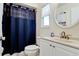 Well-lit bathroom featuring a granite vanity, decorative mirror, and a shower with a blue curtain at 3305 Notre Dame Pl # 3305, Bradenton, FL 34207