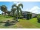 Picturesque backyard featuring lush green lawn, tropical landscaping, and a screened lanai at 362 Fairway Isles Ln, Bradenton, FL 34212