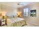 Cozy bedroom features a floral bedspread, two side tables with lamps, and tiled flooring at 362 Fairway Isles Ln, Bradenton, FL 34212