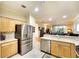 Kitchen showcasing stainless steel refrigerator, tile floors, and a breakfast bar overlooking the living space at 362 Fairway Isles Ln, Bradenton, FL 34212