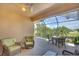 Relax in this covered lanai offering a ceiling fan and views of a sunny lawn at 362 Fairway Isles Ln, Bradenton, FL 34212
