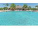 Large community swimming pool with a clubhouse and palm trees in the background on a sunny day at 362 Fairway Isles Ln, Bradenton, FL 34212