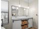 Stylish bathroom with double sinks, a modern mirror, decorative lighting, and storage beneath the vanity at 409 Archibald Ave, Sarasota, FL 34243