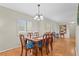Light-filled dining room with a wooden table and seating for six under a chandelier at 409 Archibald Ave, Sarasota, FL 34243