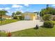 Charming one-story home featuring a well-manicured lawn, a two-car garage, and a bright yellow exterior at 409 Archibald Ave, Sarasota, FL 34243