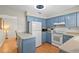 Cozy kitchen with blue cabinets, white appliances, a breakfast bar and laminate flooring at 409 Archibald Ave, Sarasota, FL 34243